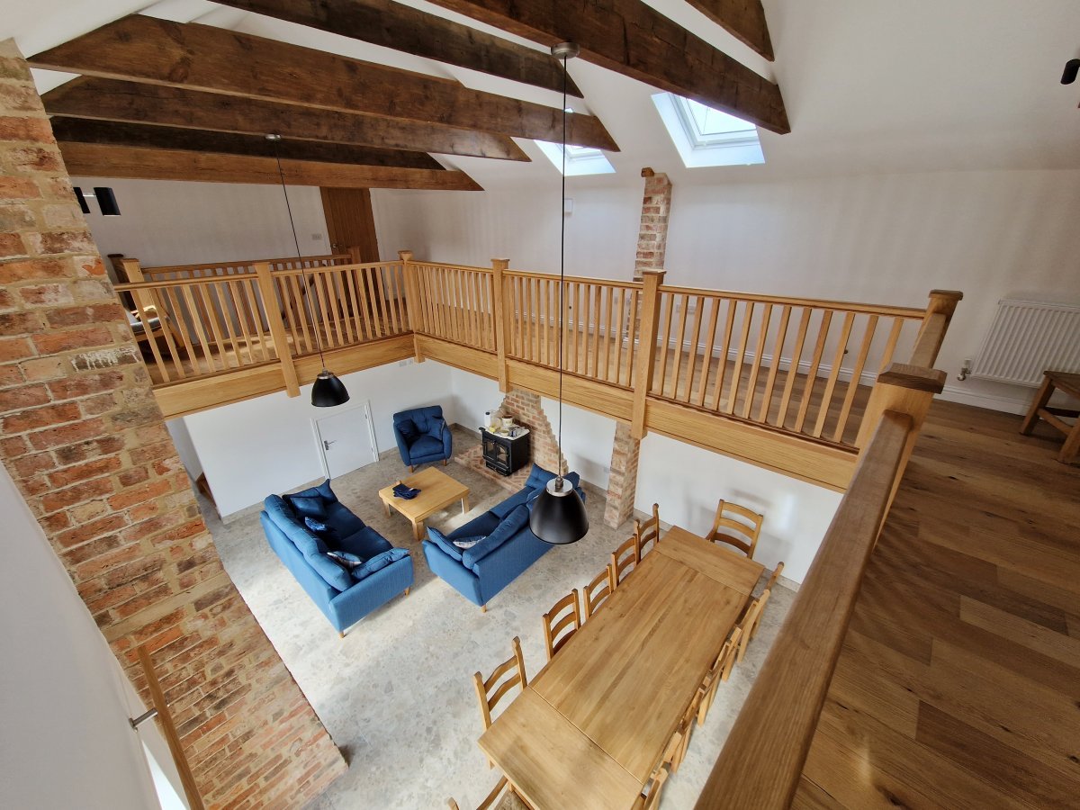 Bainvalley Cottages - looking down from the gallery to the open plan living area in the Hayloft